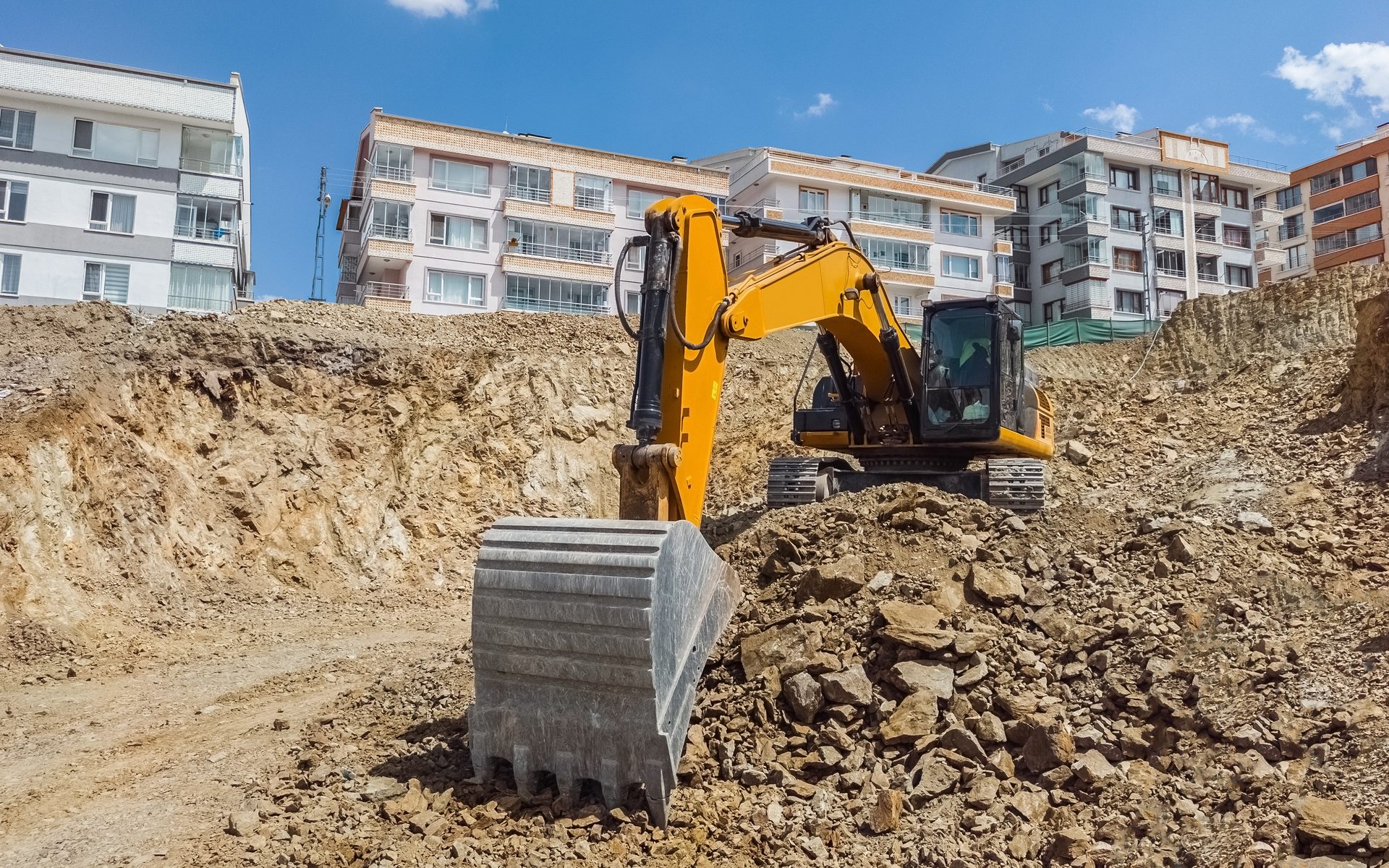 Bagger bei Erdarbeiten und Baugrubenaushub auf einer städtischen Baustelle
