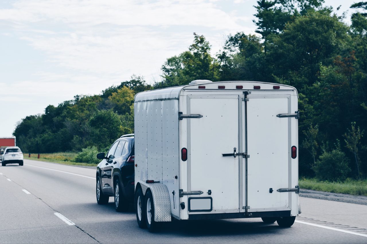 Fahrzeug mit geschlossenem Anhänger auf der Autobahn – Transport und Überführung